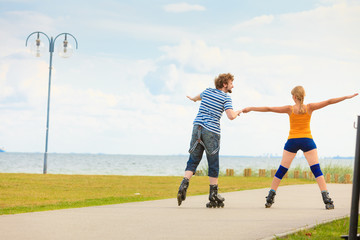 Young couple on roller skates riding outdoors