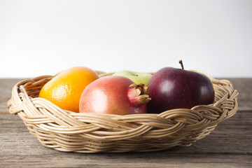 Fresh fruits in a basket on wood table