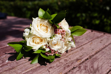 Bridal bouquet of beautiful roses for a wedding on wooden background