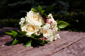 Bridal bouquet of beautiful roses for a wedding on wooden background