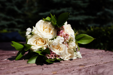 Bridal bouquet of beautiful roses for a wedding on wooden background