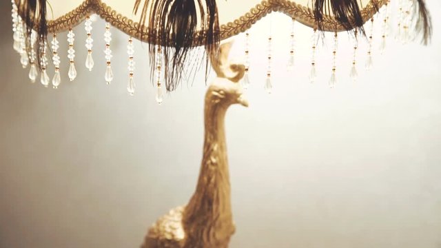 Golden chandelier- peahen on the nightstand
