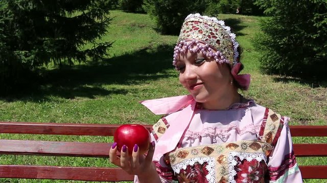 Girl in Russian folk costume and Red Apple