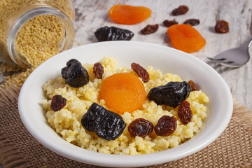 Cooked millet groats on white plate, healthy food and nutrition