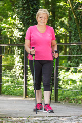 Elderly senior woman practicing nordic walking, sporty lifestyles in old age