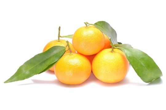 Ripe mandarin with leaves close-up on a white background