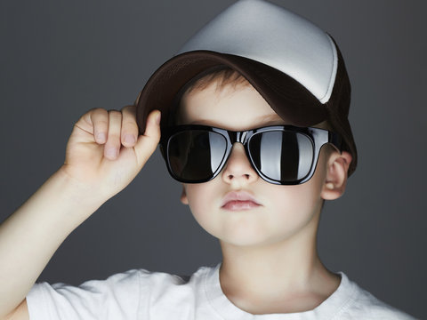 little boy in cap. fashion children.handsome in sunglasses and Tracker Hat