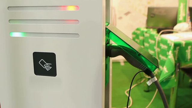 Consultant presenting latest charging point for electric vehicles at exhibition