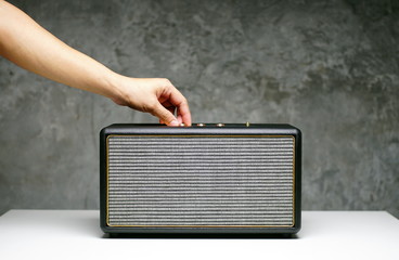 hand opening bluetooth speakers on table in the office room