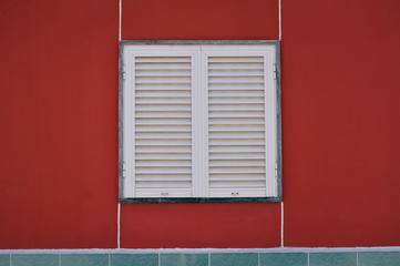 Closed window with shutters, red wall abstract design background