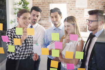 Team behind glass with colorful papers