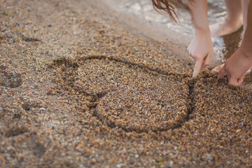 couple in love drawing a heart on the sand