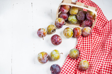 Sweet fresh plums on white wooden background
