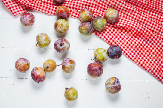 Sweet fresh plums on white wooden background