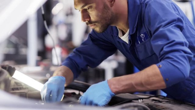 mechanic man with wrench repairing car at workshop 24