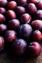Fresh plums on a dark wood background. Top view image. .Ripe Plu