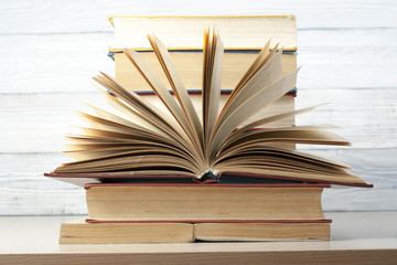 Open book, hardback books on wooden table. Education background. Back to school. Copy space for text.