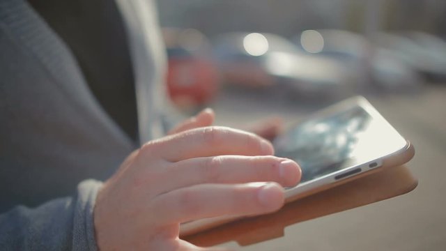 Close-up of male hands which thumbs through a news feed and reads them