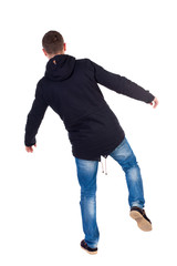 Balancing young man.  or dodge the falling man. Rear view people collection.  backside view of person.  Isolated over white background. Man in warm jacket falls while standing on the left leg.