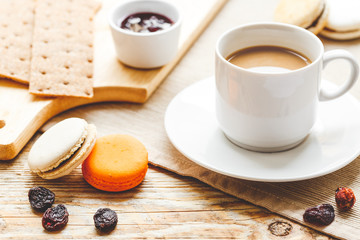 sweet breakfast with coffee, macaroons and croissants on wooden table