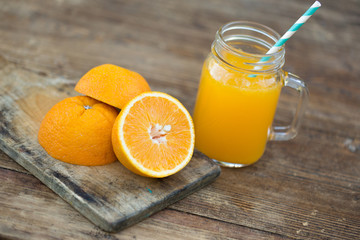 Naklejka na ściany i meble Fresh orange juice and orange sliced ripe on wooden table.