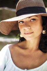 portrait of beautiful brunette woman in a straw hat