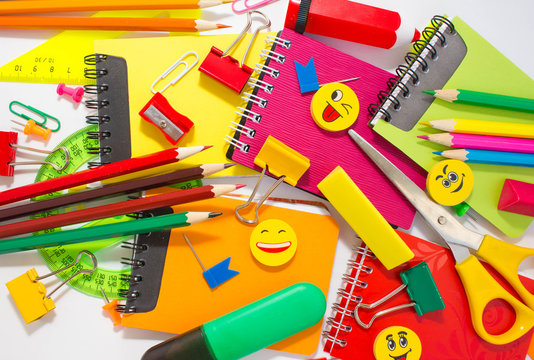 Pens, pencils, erasers, with smileys and a set of notebooks. Schoolchild and student studies accessories. Back to school concept.