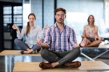 Business people performing yoga on table