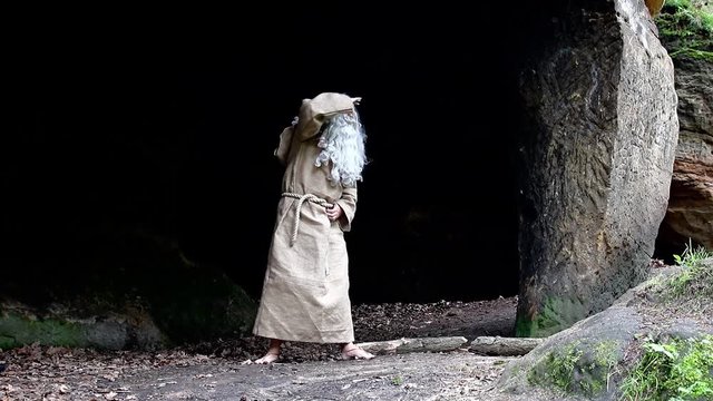 bearded hermit in a cave is watching around 