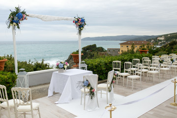 White wedding altar decorated with blue flowers stands in the fr