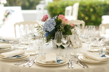 Elegant glassware stands on the table beautified with blue bouqu