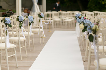 White path runs between the chairs decorated with blue flowers