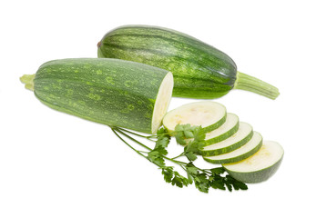 Two zucchini and sprig of parsley on a light background