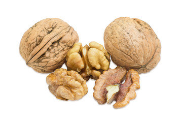 Two walnuts in their shell and several shelled kernels closeup