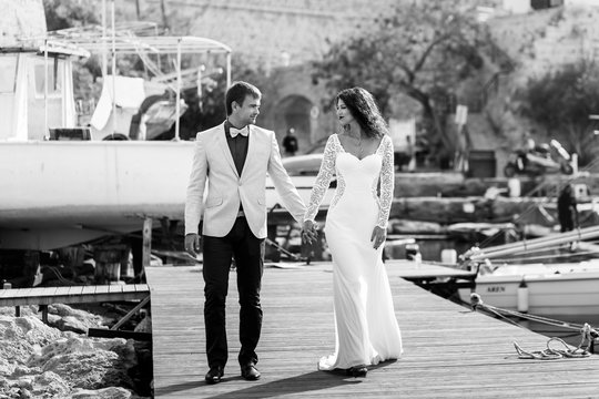 Black and white picture of a stylish wedding couple walking alon