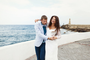 Bride puts her hand over groom's shoulder while walking along th