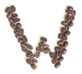Letter W made of coffee beans under a daylight isolated on white background