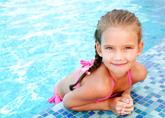 Adorable smiling little girl in swimming pool