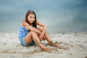 girl in a striped vest on the sand
