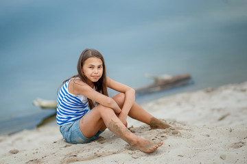 girl in a striped vest on the sand