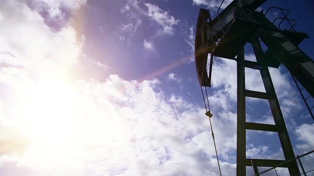Oil pump machine working over bright blue sky.