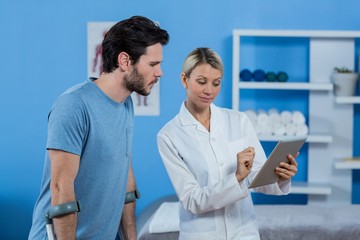 Obraz premium Physiotherapist discussing with patient over digital tablet