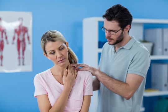 Physiotherapist stretching neck of a female patient