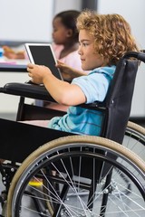 Disabled schoolboy using digital tablet