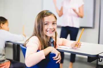 Portrait of schoolgirl smiling in classroom