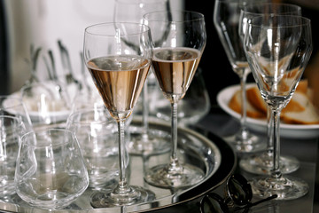 Original champagne flutes stand on a silver tray