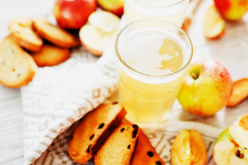 
summer and autumn cooling drink , white brew or kvass with honey , apples , raisins and bread on wooden background
