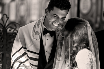 Jewish wedding. Smiling groom bends to the bride