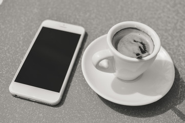 Fototapeta na wymiar Closeup on coffee cup phone screen, top view flat lay table background