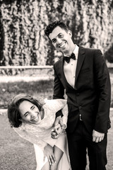 Bride squats while laughing behind a groom